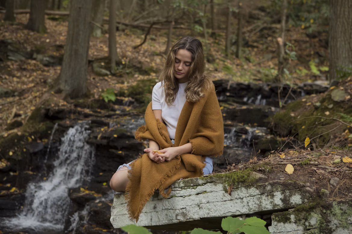A person reflecting quietly in a green setting