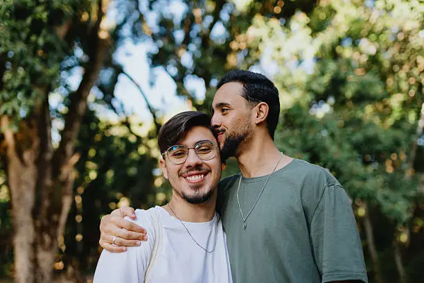 A same-sex couple sharing a close, supportive moment outdoors